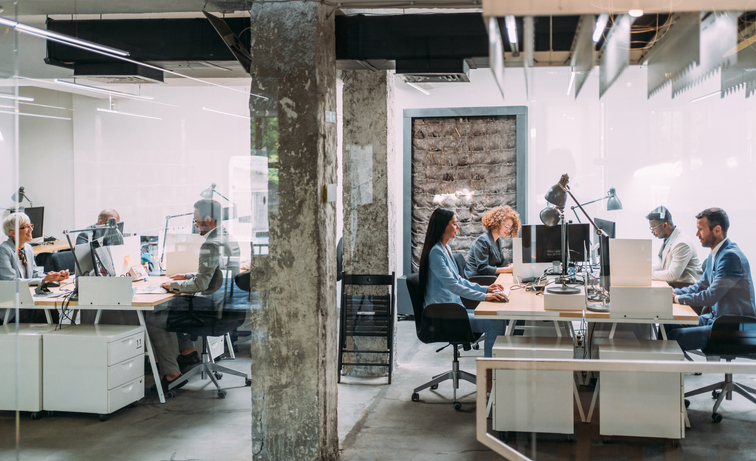 business people sitting at their desks in a busy corporate office